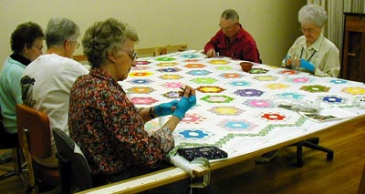 The Friends of Milwaukie Center Quilters quilting the Grandmother's Flower Garden Raffle Quilt